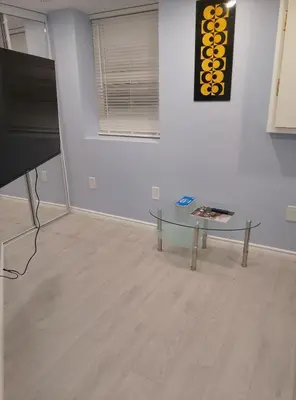 a living room with a glass table and a tv at Midtown Toronto suite in Toronto