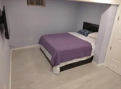 a bedroom with a bed with a purple blanket at Midtown Toronto suite in Toronto