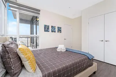 a bedroom with a bed and a large window at DT High Rise Condo w Private Patio and View in Kitchener