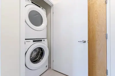 a washer and dryer in a room with a door at DT High Rise Condo w Private Patio and View in Kitchener