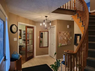 a hallway with a staircase and a chandelier at 308 Delancey in Hamilton