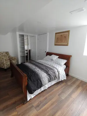 a bedroom with a large bed with a wooden floor at Two bedroom on Toronto Greenhills in Toronto