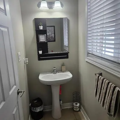 a bathroom with a white sink and a mirror at Exquisite Junior Bedroom in Brampton