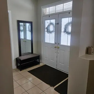 a hallway with two doors and a bench in a room at Exquisite Junior Bedroom in Brampton