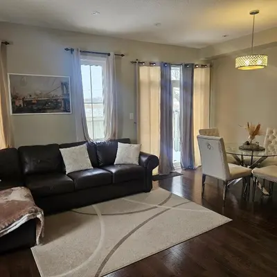 a living room with a black couch and a table at Exquisite Junior Bedroom in Brampton