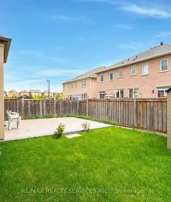 a yard with a wooden fence and a bench at Beautiful 4 bed 3 master bedrooms-pvt washrooms in Brampton