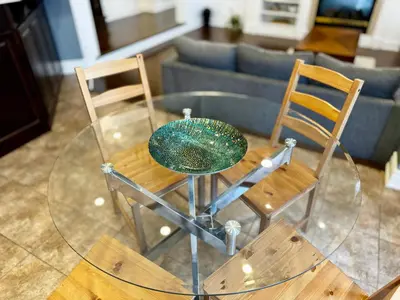 a glass table with two chairs and a couch at Connected Comfort - 7BR Family Retreat - Near Pearson Airport & Toronto Downtown in Brampton