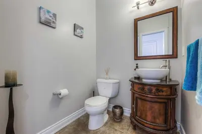 a bathroom with a toilet and a sink and a mirror at Connected Comfort - 7BR Family Retreat - Near Pearson Airport & Toronto Downtown in Brampton