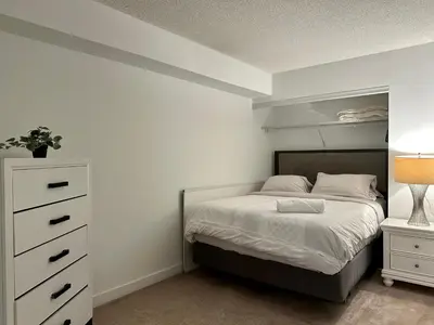 a bedroom with a bed and a dresser at Spacious & Central 1 bdrm 2 real beds in Toronto