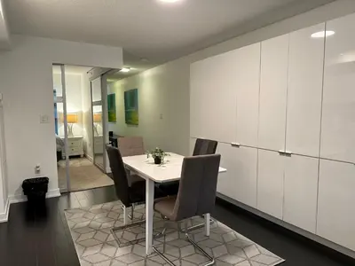 a dining room with a white table and chairs at Spacious & Central 1 bdrm 2 real beds in Toronto