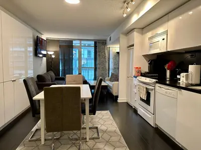 a kitchen and living room with a table and a couch at Spacious & Central 1 bdrm 2 real beds in Toronto