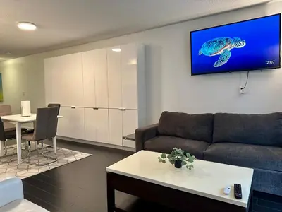 a living room with a couch and a tv on the wall at Spacious & Central 1 bdrm 2 real beds in Toronto