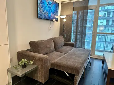 a living room with a couch and a table at Spacious & Central 1 bdrm 2 real beds in Toronto