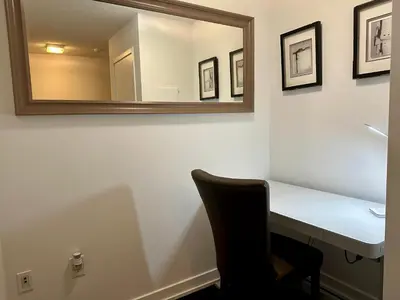 a mirror on a wall above a desk with a chair at Spacious & Central 1 bdrm 2 real beds in Toronto
