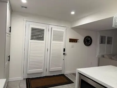 a kitchen with white doors and a clock on the wall at Modern & Stylish 2BR Apartment 658 in Peterborough
