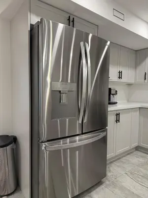 a stainless steel refrigerator in a kitchen with white cabinets at Modern & Stylish 2BR Apartment 658 in Peterborough