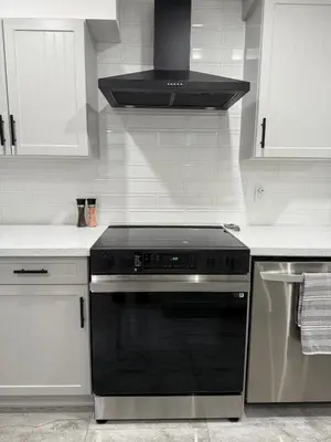 a kitchen with a black stove and white cabinets at Modern & Stylish 2BR Apartment 658 in Peterborough