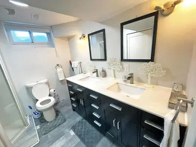 a bathroom with two sinks and a toilet and a shower at Hamilton Chic Retreat - Cozy Winter Getaway in Hamilton