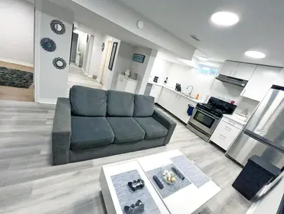 a living room with a couch and a kitchen at Hamilton Chic Retreat - Cozy Winter Getaway in Hamilton