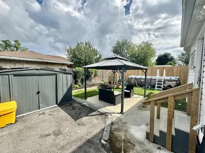 a patio with an umbrella next to a house at Hamilton Chic Retreat - Cozy Winter Getaway in Hamilton
