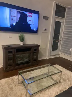 a living room with a tv and a glass coffee table at Cityscape in Mississauga