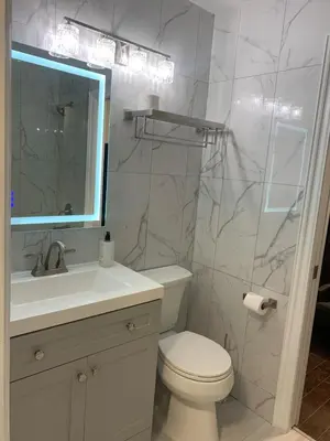 a bathroom with a toilet and a sink and a mirror at Cityscape in Mississauga