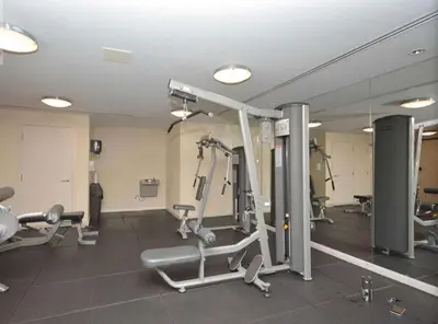 a gym with several tread machines and a mirror at Cityscape in Mississauga