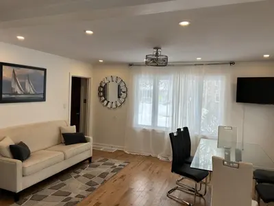 a living room with a couch and a table at Serenity Charm - Walk in Town, Shaw, Hottub in Niagara on the Lake