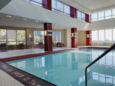 a large swimming pool with blue water in a building at Urban Oasis - Modern 1 bedroom w pool access free parking in Toronto