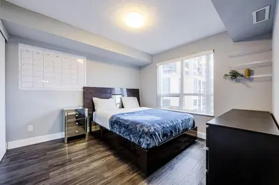 a bedroom with a bed and a large window at Urban Oasis - Modern 1 bedroom w pool access free parking in Toronto
