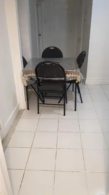 a table and chairs sitting on a white tiled floor at Two Separate Units in Richmond Hill