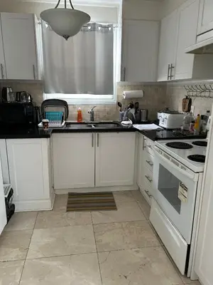 a kitchen with white cabinets and a white stove top oven at Two Separate Units in Richmond Hill