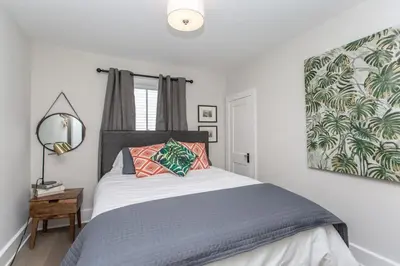 a bedroom with a bed and a large picture on the wall at Boutique Quality Home Downtown by the Shaw in Niagara on the Lake