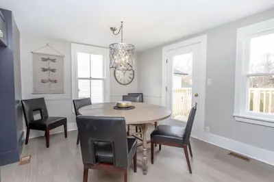 a dining room with a wooden table and black chairs at Boutique Quality Home Downtown by the Shaw in Niagara on the Lake