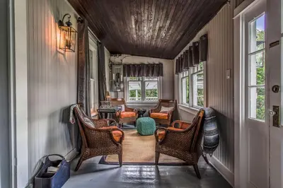 a hallway with wicker chairs and a living room at Boutique Quality Home Downtown by the Shaw in Niagara on the Lake