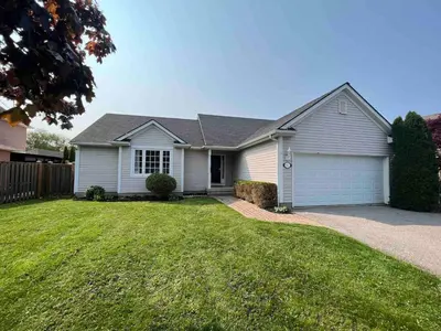 a white house with a grass yard at Boutique Quality in Old Towne with Hot Tub in Niagara on the Lake