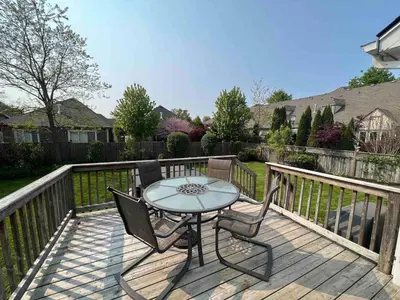 a patio with a table and chairs on a deck at Boutique Quality in Old Towne with Hot Tub in Niagara on the Lake