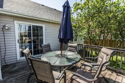 a patio with a table and chairs and an umbrella at Boutique Quality in Old Towne with Hot Tub in Niagara on the Lake