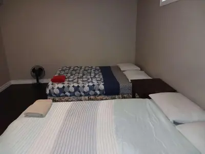a group of three beds in a room at Cosy Romantic and Cost Effective Stay in Kitchener in Kitchener