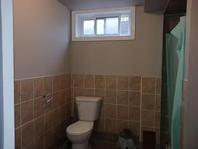 a bathroom with a toilet and a window at Cosy Romantic and Cost Effective Stay in Kitchener in Kitchener