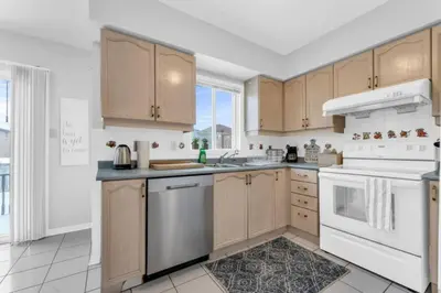 a kitchen with wooden cabinets and white appliances at Spacious 4BR Home with Parking in Richmond Hill
