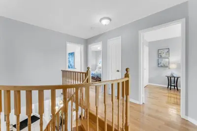 a staircase in a home with white walls and wood floors at Spacious 4BR Home with Parking in Richmond Hill