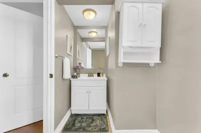 a white bathroom with a sink and a mirror at Spacious 4BR Home with Parking in Richmond Hill