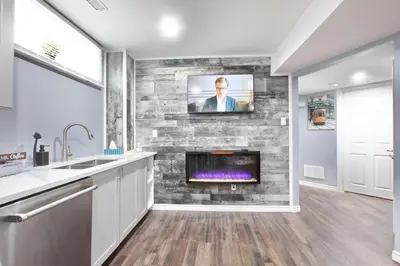 a kitchen with a fireplace and a tv on a stone wall at Deluxe Apartment in Caledon