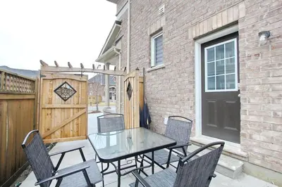 a patio with a table and chairs and a fence at Deluxe Apartment in Caledon
