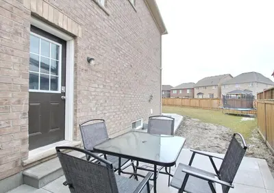 a patio with a table and chairs and a building at Deluxe Apartment in Caledon