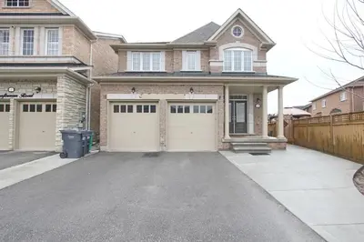 a house with two garage doors in a driveway at Deluxe Apartment in Caledon