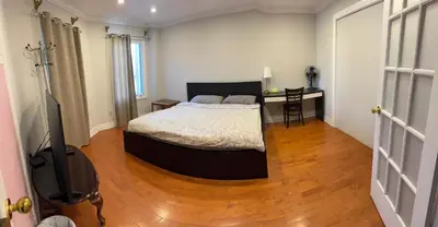 a bedroom with a bed and a desk in it at Large private room in Mississauga