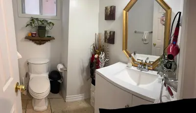 a bathroom with a sink and a toilet and a mirror at Large private room in Mississauga