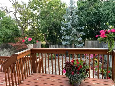 a wooden deck with two potted plants and flowers at Large private room in Mississauga